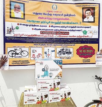 மதுரை மாவட்ட ஆட்சியர் அலுவலகத்தில் தடுப்பூசி போட்டுக்கொள்வோருக்கு வழங்கப் படுவதாக அறிவித்துள்ள சைக்கிள், குக்கர், மிக்ஸி உள்ளிட்ட பரிசுப் பொருட்கள்.