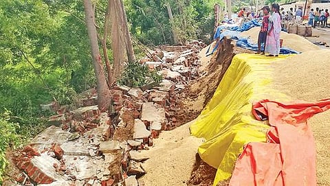 தஞ்சாவூர் அருகே கரந்தை பூக்குளம் நெல் கொள்முதல் நிலையத்தின் அருகே மழையினால் சாலையோர தடுப்பு சுவர் இடிந்து விழுந்ததில் சேதமான நெல்குவியல்கள்.