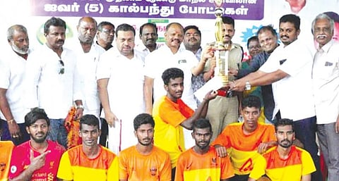 திண்டுக்கல்லில் நடந்த ஐவர் கால்பந்து போட்டியில் முதலிடம் பிடித்த தேனி அணிக்கு சுழற்கோப்பையை வழங்கிய ஜி.டி.என் கலைக் கல்லூரி தாளாளர் ரெத்தினம், மாவட்டக் கால்பந்து கழகச் செயலாளர் சண்முகம் உள்ளிட்டோர்.