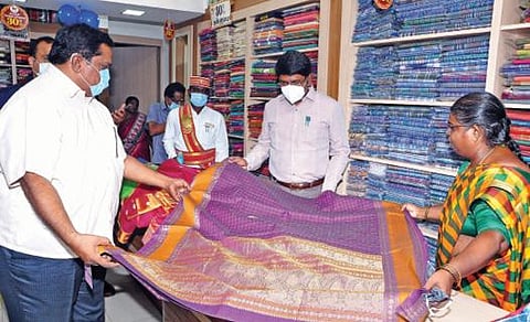 விழுப்புரம் கோ ஆப்டெக்ஸ் விற்பனை நிலையத்தில் பட்டு சேலைகளை பார்வையிடும் ஆட்சியர் மோகன் .