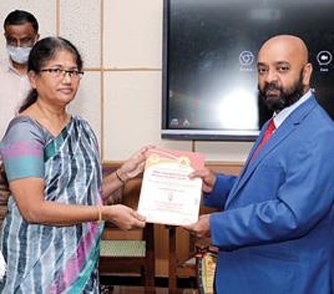 அமெரிக்கன் கல்லூரி முதல்வர் தவமணி கிறிஸ்டோபருக்கு சிறந்த முதல்வருக்கான விருதை வழங்கிய காமராசர் பல்கலைக்கழகப் பதிவாளர் வசந்தா.