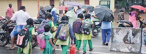 கிருஷ்ணகிரியில் மழையில் நனைந்தபடி பள்ளிக்குச் சென்ற மாணவிகள்.