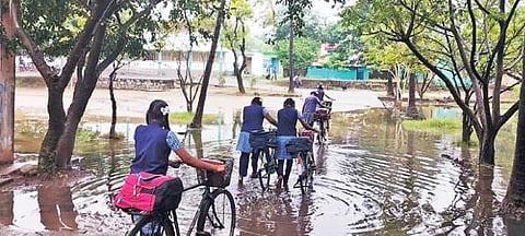 அகரம் அரசு மேல்நிலைப்பள்ளி வளாகத்தில் தேங்கிய மழைநீரில் நடந்து சிரமத்துடன் வகுப்பறைகளுக்கு சென்ற மாணவ, மாணவிகள்.