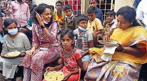 புதுச்சேரி ஆரியபாளையத்தில் மழையால் பாதிக்கப்பட்டு தங்க வைக்கப் பட்டுள்ள சிறுவர்களுடன் அமர்ந்து உணவருந்திய துணைநிலை ஆளுநர் தமிழிசை சவுந்தர ராஜன். உடன் ஆட்சியர் பூர்வா கார்க். படம்: எம்.சாம்ராஜ்