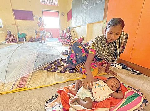 கொசஸ்தலை ஆற்றில் ஏற்பட்ட வெள்ளப் பெருக்கு காரணமாக சென்னை, மணலி புதுநகர் பகுதியில் உள்ள வீடுகளை வெள்ளநீர் சூழ்ந்ததால் நிவாரண முகாமில் தனது குழந்தையுடன் தங்க வைக்கப்பட்டுள்ள பெண். (அடுத்த படம்) கொசஸ்தலை ஆற்றில் ஏற்பட்ட வெள்ளப் பெருக்கு காரணமாக சென்னை, மணலி புதுநகர் பகுதியில் உள்ள வீடுகளை சூழ்ந்துள்ள வெள்ளநீர். படங்கள்: பு.க.பிரவீன்