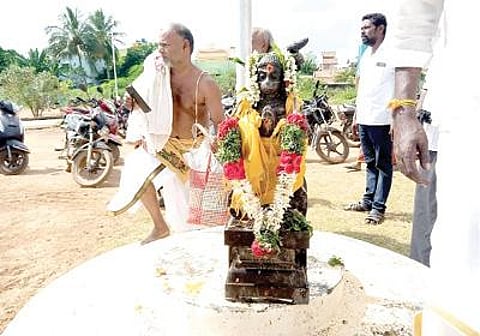 காளையார்கோவில் வட்டாட்சியர் அலுவலகம் முன் கொடி கம்பம் கீழே வைக்கப்பட்ட ஆஞ்சநேயர் சிலை.