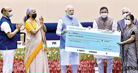 டெல்லியில் நேற்று நடைபெற்ற வங்கி வைப்புத் தொகை திட்டம் தொடர்பான நிகழ்ச்சியில் பயனாளி ஒருவருக்கு காசோலை வழங்குகிறார் பிரதமர் நரேந்திர மோடி. உடன் மத்திய நிதி அமைச்சர் நிர்மலா சீதாராமன், ரிசர்வ் வங்கி கவர்னர் சக்திகாந்த தாஸ், மத்திய நிதித் துறை இணை அமைச்சகர்கள் பகவத் கிஷன்ராவ் காரத் மற்றும் பங்கஜ் சவுத்ரி.படம்: பிடிஐ