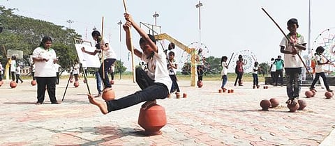 விருதுநகரில் நடைபெற்ற சாதனை நிகழ்ச்சியில் மண்பானையின் மீது ஏறி நின்று சிலம்பம் சுற்றிய மாணவ, மாணவிகள்.