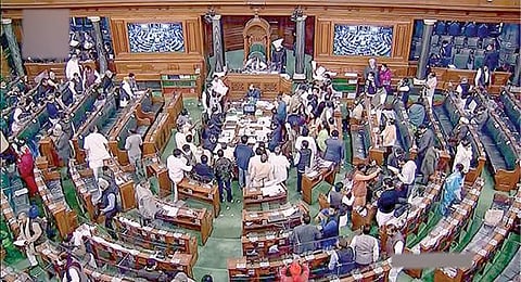 தேர்தல் சட்டத் திருத்த மசோதாவுக்கு எதிர்ப்பு தெரிவித்து எதிர்க்கட்சி எம்.பி.க்கள் நேற்று மக்களவையின் மையப் பகுதியில் கூடி அமளியில் ஈடுபட்டனர். படம்: பிடிஐ