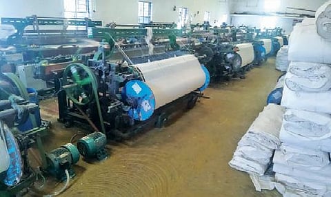 பல்லடத்தில் கூலிக்கு நெசவு செய்யும் விசைத்தறியாளர்கள் வேலைநிறுத்த போராட்டத்தில் ஈடுபட்டுள்ளதால், தொழிலாளர்கள் இன்றி காணப்படும் விசைத்தறிக்கூடம்.