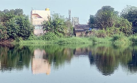 திருக்காலிமேடு பகுதியில் இந்திரன் தீர்த்தக் குளத்தின் கரையை ஆக்கிரமித்து அமைக்கப்பட்டுள்ள வீடுகள்.