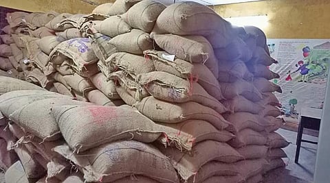 காமராஜ் நகர் அரசு தொடக்கப்பள்ளியில் வகுப்பறையில் வைக்கப்பட்டுள்ள அரிசி மூட்டைகள்.