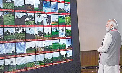 பூச்சிக்கொல்லி தெளித்தல், விளைபொருட்களை சந்தைக்கு அனுப்புதல் உள்ளிட்ட வேளாண் பணிகளுக்கு ட்ரோன்களை பயன்படுத்தும் திட்டத்தை பிரதமர் நரேந்திர மோடி நேற்று தொடங்கி வைத்தார். அப்போது 100 ட்ரோன்கள் நாட்டின் வெவ்வேறு வேளாண் நிலங்களில் பறப்பதை டெல்லியிலிருந்தபடி காணொலி வாயிலாக பார்வையிட்டார். படம்: பிடிஐ