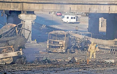 தாக்குதலில் சிக்கிய ராணுவ வாகனங்கள் எரிந்து சாம்பலான நிலையில் அவற்றை ஆய்வு செய்கிறார் உக்ரைன் வீரர். படம் : பிடிஐ