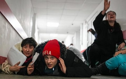 மரியுபோலில் விமான தாக்குதல் சைரன் கேட்டவுடன் மருத்துவமனையிலிருந்த சிலர் தரையில் படுத்து தங்களை தற்காக்க முயன்றனர்.