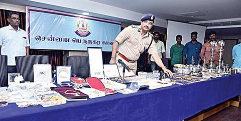 கொலையாளிகளிடம் இருந்து பறிமுதல் செய்யப்பட்ட நகை, வெள்ளி பாத்திரங்களுடன் கூடுதல் காவல் ஆணையர் கண்ணன்.