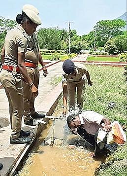 தி.மலை ஆட்சியர் அலுவலக முகப்பில் மண்ணெண்ணெய் ஊற்றிக் கொண்ட குணசேகரன் மீது, காவல்துறையினர் தண்ணீரை ஊற்றினர்.