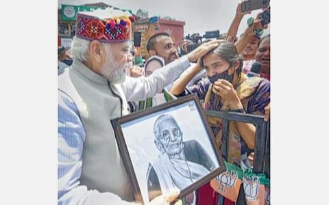 சிம்லாவில் நேற்று நடந்த விழாவில் பிரதமர் மோடியின் தாயார் ஹீராபென் னின் ஓவியத்தை அனு என்பவர் பிரதமருக்கு பரிசாக அளித்தார். படம்: பிடிஐ