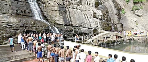 குற்றாலம் பிரதான அருவியில் நேற்று குறைந்த அளவில் தண்ணீர் விழுந்ததால் வரிசையில் காத்திருந்து குளித்த சுற்றுலாப் பயணிகள்.