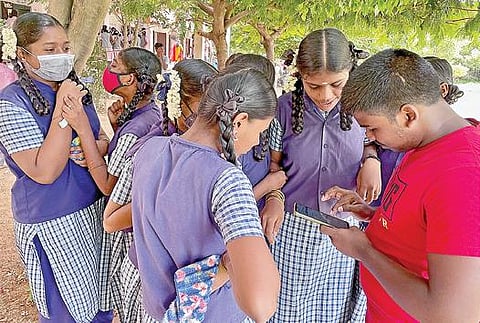 பிளஸ் 1 தேர்வு முடிவுகள் நேற்று வெளியிடப்பட்டன. பெருங்களத்தூர் அரசு பள்ளியில் செல்போன் மூலம் ஆன்லைனில் தேர்வு முடிவுகளை காணும் மாணவ, மாணவியர். படம்: எம்.முத்துகணேஷ்