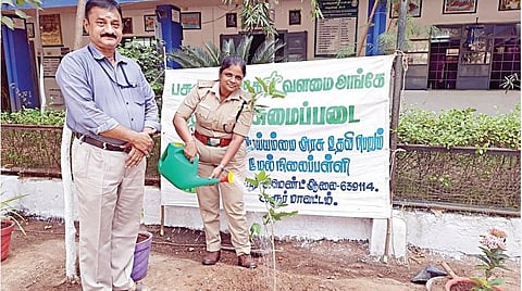 பள்ளி வளாகத்தில் மரக்கன்று நடும் பெண் காவல்துறை அதிகாரி