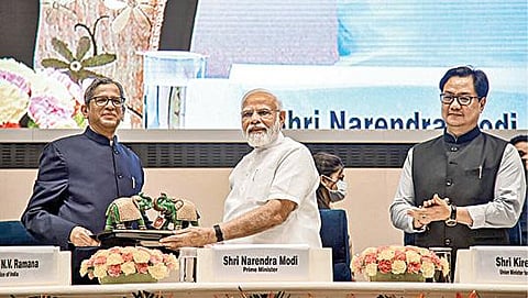 டெல்லியில் நேற்று நடைபெற்ற மாவட்ட சட்டப் பணிகள் ஆணையத்தின் கூட்டத்தில் பிரதமர் நரேந்திர மோடிக்கு உச்ச நீதிமன்ற தலைமை நீதிபதி என்.வி.ரமணா நினைவு பரிசினை வழங்கினார். உடன் மத்திய சட்ட அமைச்சர் கிரண் ரிஜிஜு உள்ளார்.படம்: பிடிஐ