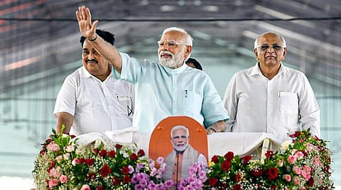 பல்வேறு வளர்ச்சித் திட்டங்களை தொடங்கிவைப்பதற்காக, பிரதமர் நரேந்திர மோடி நேற்று குஜராத் சென்றார். சூரத் நகரில் நடந்த பேரணியில் தொண்டர்களை நோக்கி கையசைத்த பிரதமர் மோடி. படம்: பிடிஐ.