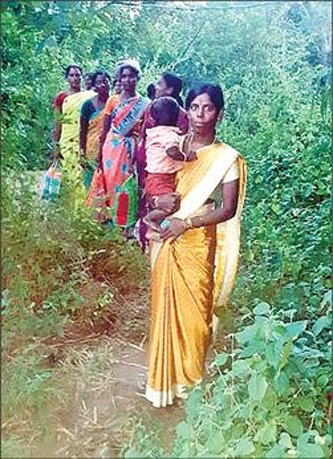 சாலை வசதி இல்லாததால் மலை வழியாக நடந்து செல்லும் பெண்கள்.
