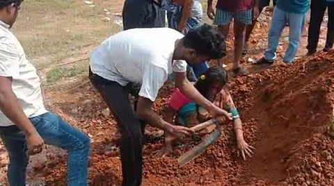 மண்ணில் புதைக்கப்பட்ட சாவித்ரியை மீட்கும் பொதுமக்கள்.