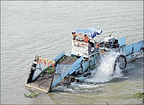 கங்கையின் மேற்பரப்பில் படர்ந்திருக்கும் கழிவுகள், மிதவை இயந்திரம் மூலம் அகற்றப்படுகின்றன.