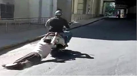 வாகனத்தில் இழுத்துச் செல்லப்படும் முதியவர்.