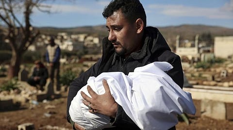 பூகம்பத்தால் உயிரிழந்த குழந்தையை தூக்கிச்செல்லும் உறவினர்