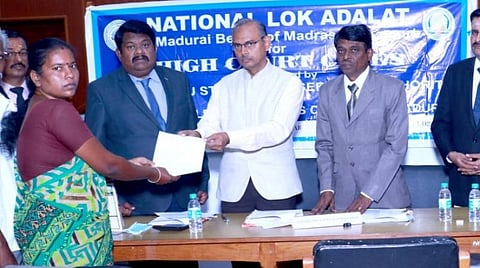 உயர் நீதிமன்ற மதுரை கிளையில் மக்கள் நீதிமன்றத்தில் வழக்கு தொடர்ந்தவர்களுக்கு உத்தரவு நகல் வழங்குகிறார் நீதிபதி ஆர்.விஜயகுமார்.