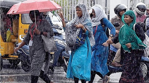 சென்னை பூந்தமல்லி நெடுஞ்சாலையில் நேற்று பெய்த மழையில் நனைந்தபடி செல்லும் இளம்பெண்கள். படம்: பி.ஜோதிராமலிங்கம்