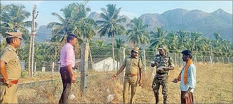 உடுமலை அருகே வன எல்லையில் தாழ்வாக செல்லும் மின் கம்பிகள் குறித்த ஆய்வில் ஈடுபட்ட மாவட்ட உதவி வனப் பாதுகாவலர் கணேஷ்ராம், வன அலுவலர் சிவக்குமார்.