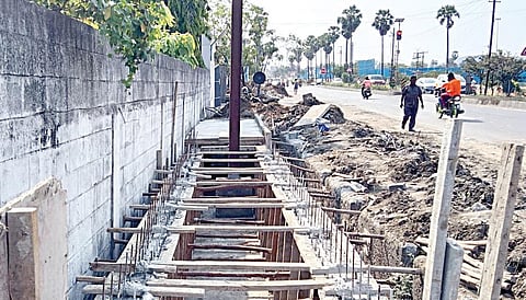 வண்டலூர் கேளம்பாக்கம் சாலை கொளப்பாக்கத்தில் அமைக்கப்பட்டு வரும் மழைநீர் கால்வாய் நடுவே உள்ள இரும்பு மின் கம்பம்.