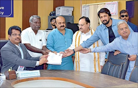 வரும் மே 10-ம் தேதி நடைபெறவுள்ள கர்நாடக சட்டப்பேரவைத் தேர்தலில் ஷிகோன் தொகுதியில் முதல்வர் பசவராஜ் பொம்மை போட்டியிடவுள்ளார். இதற்காக நேற்று ஷிகோன் தொகுதியில் அவர் வேட்புமனு தாக்கல் செய்தார். உடன் பாஜக தேசியத் தலைவர் ஜே.பி. நட்டா, கன்னட நடிகர் கிச்சா சுதீப் உள்ளனர். படம்: பிடிஐ