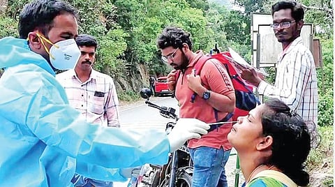 கொடைக்கானலில் சுற்றுலாப் பயணிக்கு கரோனா பரிசோதனை மேற்கொண்ட சுகாதாரத் துறையினர்.