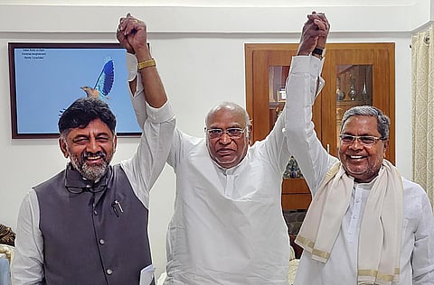 கர்நாடக முதல்வராகத் தேர்வு செய்யப்பட்டுள்ள சித்தராமையா (வலது), துணை முதல்வராகும் டி.கே.சிவகுமாருடன் காங்கிரஸ் தேசியத் தலைவர் மல்லிகார்ஜுன கார்கே. படம்: பிடிஐ