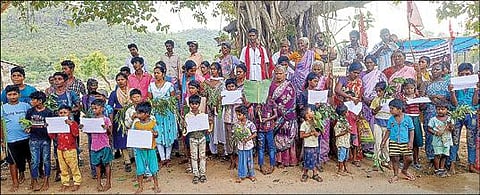 திருவண்ணாமலை அடுத்த புனல்காடு குப்பை கிடங்கை அகற்ற வலியுறுத்தி 10-வது நாளாக நேற்று நடைபெற்ற காத்திருப்பு போராட்டத்தில் மண் வளத்தை பாதுகாக்க கைகளில் செடிகளுடன் பங்கேற்ற சிறுவர்கள்.