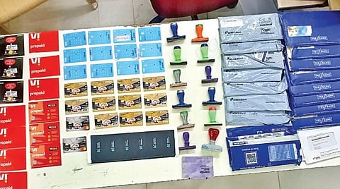 பறிமுதல் செய்யப்பட்ட சிம்கார்டுகள், ஏடிஎம் கார்டுகள் மற்றும் 12 போலி ரப்பர் ஸ்டாம்புகள்.