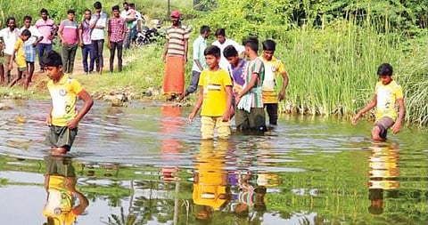 வேப்பனப்பள்ளி அருகே மாமிடிகும்மனப்பள்ளியிலிருந்து எட்ரப்பள்ளி கிராமத்துக்கு மார்க்கண்டேய நதியைச் சிரமத்துடன் கடந்து செல்லும் சிறுவர்கள்.
