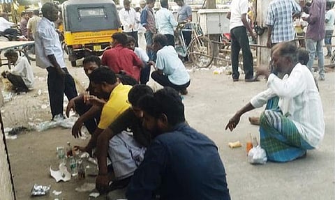 வேலூர் பழைய பேருந்து நிலையம் அருகே சற்றும் சலனமின்றி பொதுஇடத்தில் அமர்ந்து மது அருந்தும் மதுப் பிரியர்கள்.