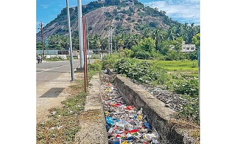 சிவகிரிபட்டி பைபாஸ் சாலையில் இருந்து பழநி மலைக்கோயிலுக்கு செல்லும் சாலையில் சாக்கடை கால்வாயில் கிடக்கும் குப்பைகள்.