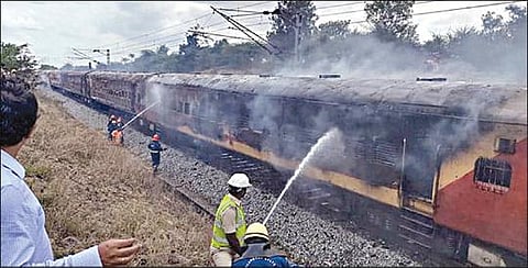 தீயை கட்டுப்பாட்டுக்குள் கொண்டு வரும் தீயணைப்பு படையினர்.