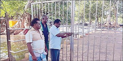 ஒகேனக்கல் பிரதான அருவிக்குச் செல்லும் பாதையைப் பூட்டிய பென்னாகரம் வட்டார வளர்ச்சி அலுவலகப் பணியாளர்கள்.