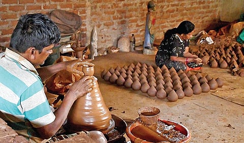 திண்டுக்கல் அருகே சுடுமண் விளக்குகள் தயாரிப்பின் முதற்கட்டமாக களிமண்ணில் விளக்குகளை வார்த்து எடுக்கும் பணியாளர்.