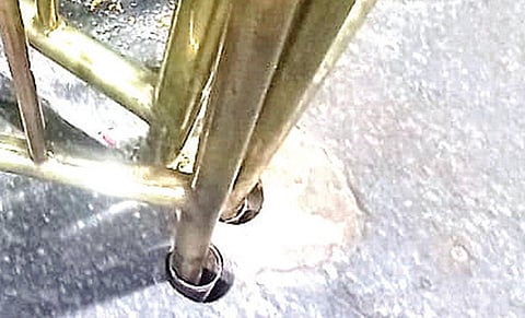 கோயிலில் உள்ள தரையில் பதிக்கப்பட்டிருந்த கருங்கற்களில் துளையிட்டு வைக்கப்பட்டுள்ள தடுப்பு கம்பிகள்.