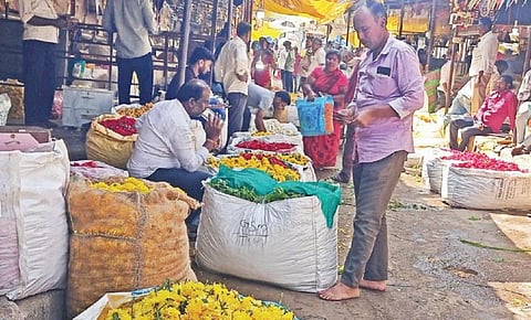 பூக்கள் வரத்து குறைவால் விற்பனை பரபரப்பின்றி வெறிச்சோடி காணப்படும் ஓசூர் மலர் சந்தை.