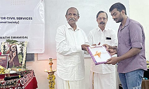 முன்னாள் எம்எல்ஏ நட்ராஜ் ஐபிஎஸ் மாணவருக்கு சேர்க்கை அடையாளமாக புத்தகம் வழங்குகிறார். (உடன்) பிஎஸ் குழும பொருளாளர் பிரபாகர்.